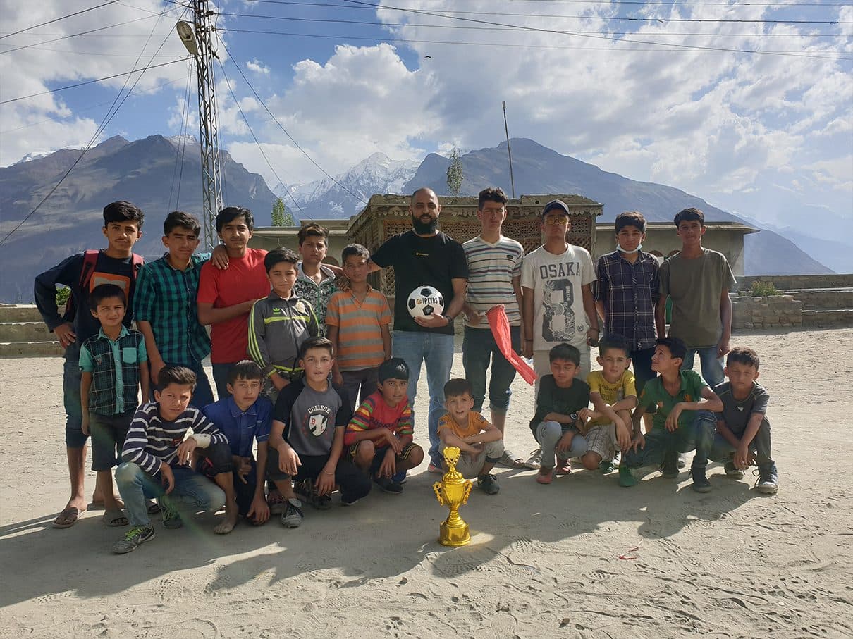 Young players with a PLYRS football and a trophy after a tournament in the mountains of Pakistan