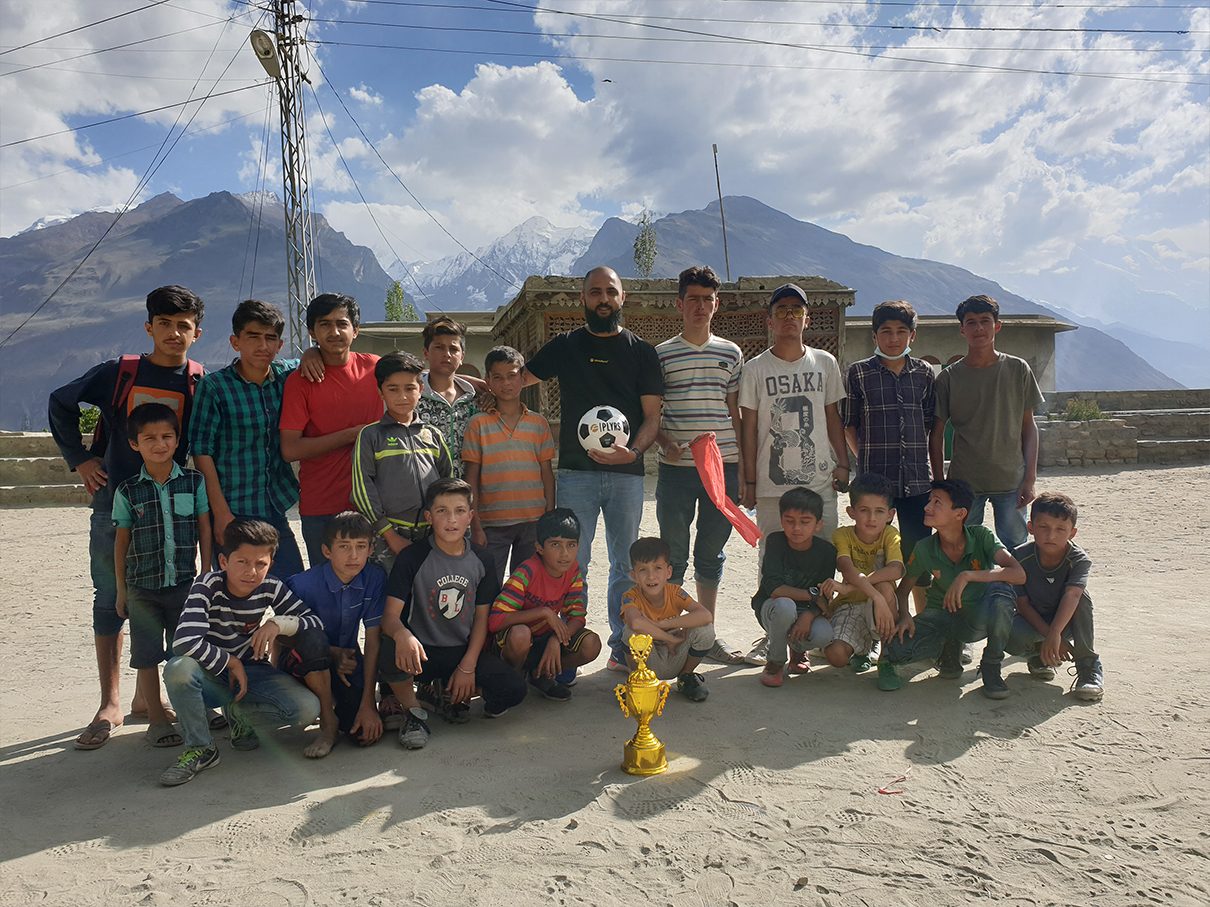 Young players with a PLYRS football and a trophy after a tournament in the mountains of Pakistan